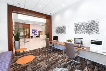 A modern office with a purple sofa and a wooden desk.